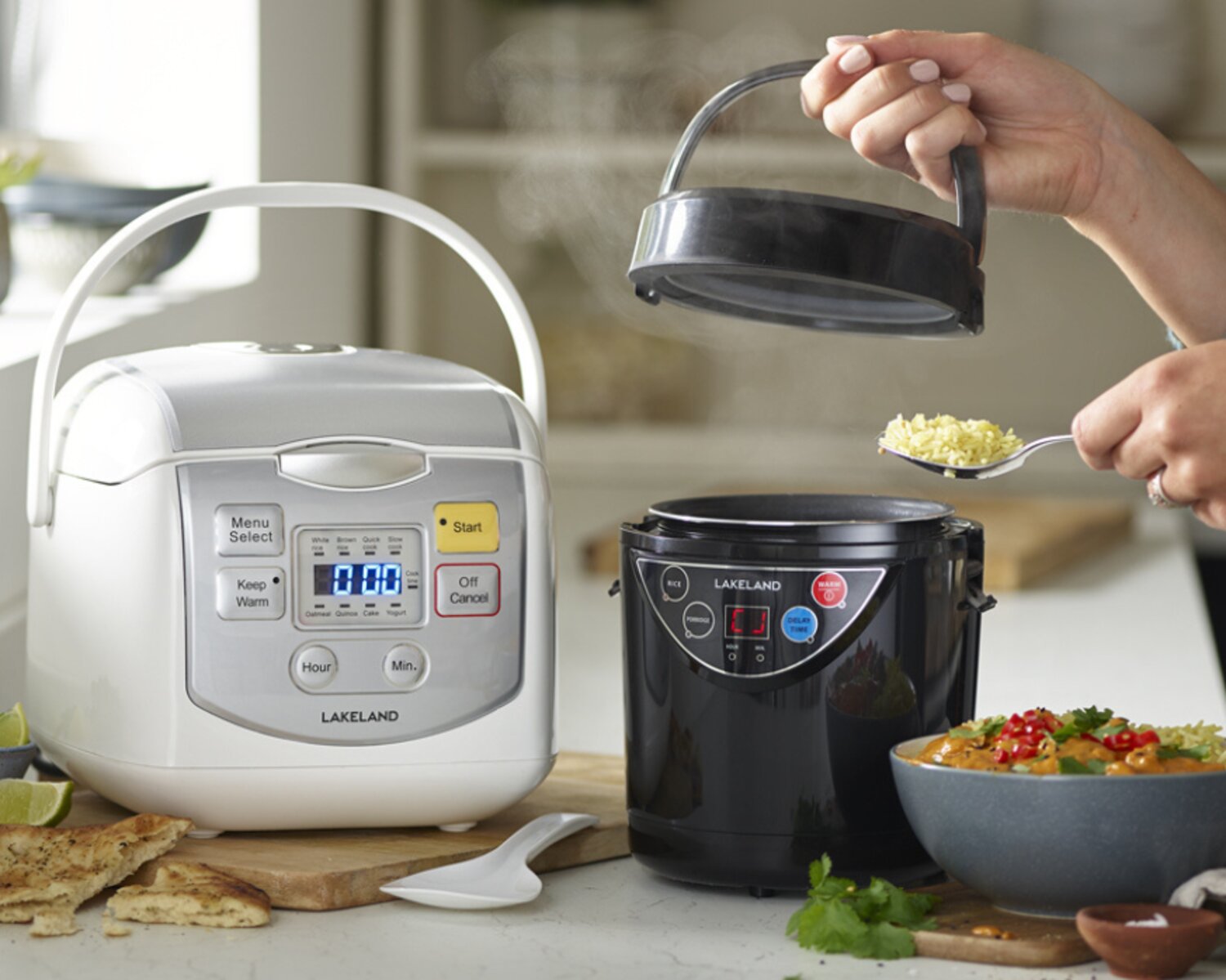 Two Lakeland rice cookers displayed on a kitchen worktop with a home-made curry dish