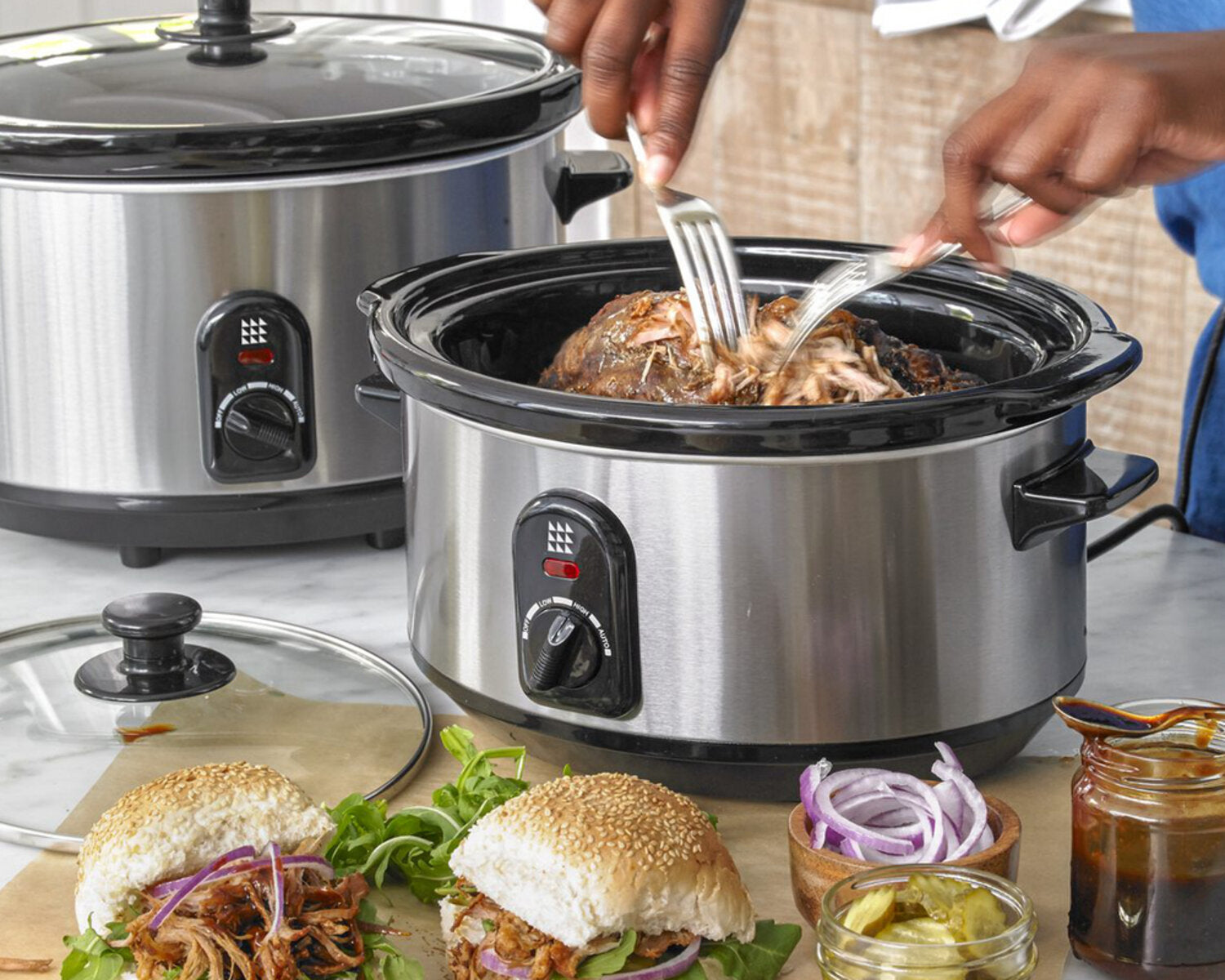 slow cooker pulled pork being torn apart
