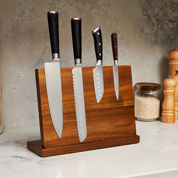 Four knives attached to a wooden magnetic knife block
