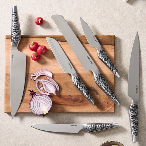 A set of knives displayed on a chopping board.